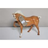 A Beswick horse figure - front foot raised