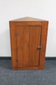 An antique pine corner cabinet