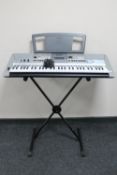 A Yamaha PRS E413 electric keyboard on stand with lead