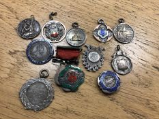 A collection of silver fobs and medals
