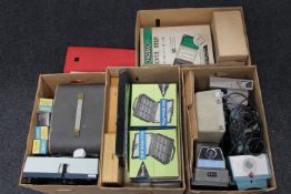 Four boxes containing vintage projectors, slide supporters,