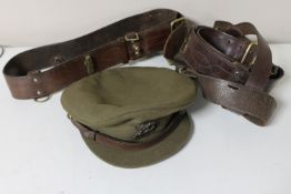 A basket containing a British army officer's cap together with three military leather belts