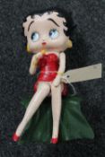 A cast iron figure of a seated Betty Boop with microphone