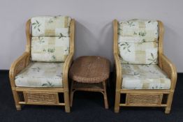 A pair of bamboo and wicker conservatory armchairs and a wicker coffee table