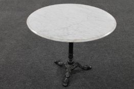 A circular marble topped bistro table on cast iron pedestal