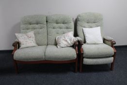 A two piece wood framed lounge suite upholstered in green buttoned fabric comprising two seater