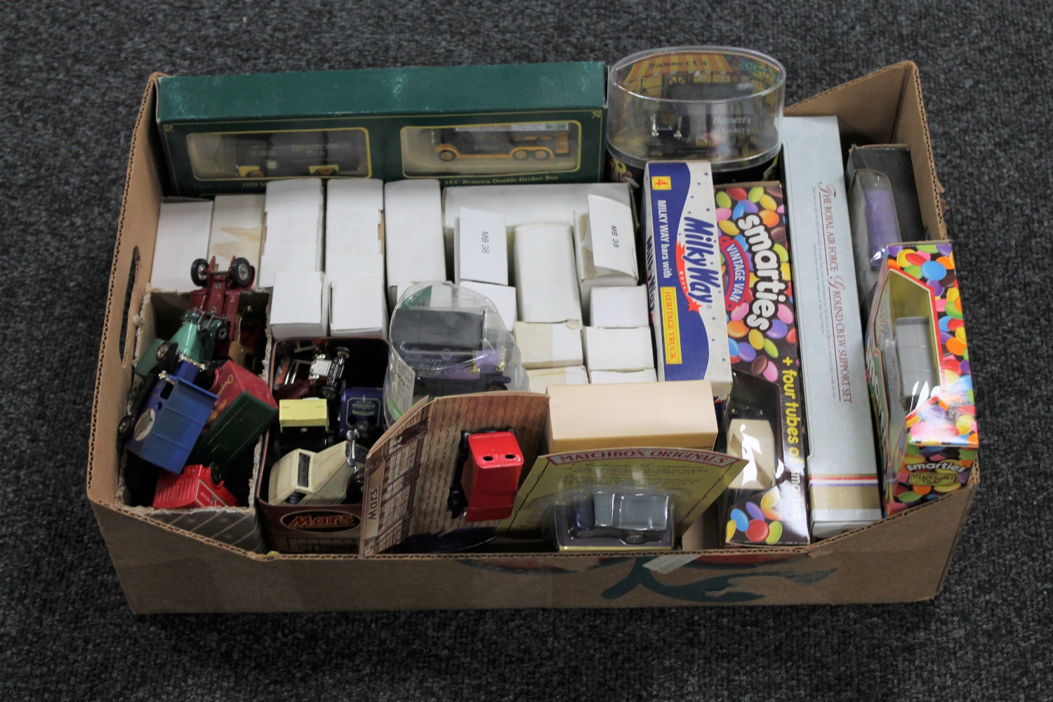 A box containing assorted boxed and unboxed die cast vehicles including Ringtons Transport,