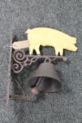 A cast iron pig wall bracket with bell