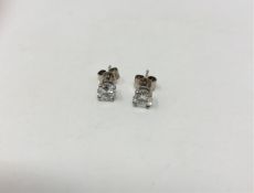 A pair of solitaire diamond earrings, 1ct in platinum.