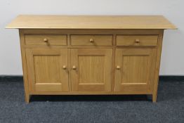 A contemporary oak triple door sideboard fitted three drawers