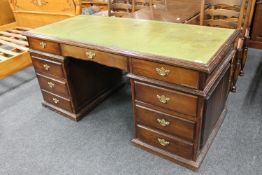 An oak twin pedestal desk with green tooled leather top,