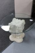 A circular glass topped occasional table on lion base