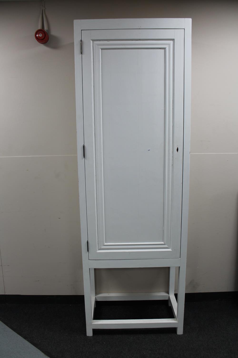 A painted pine single door cupboard on raised legs