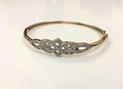 A 9ct gold diamond set bangle, the stated total diamond weight 0.