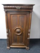 An early 20th century continental oak single door cabinet fitted a drawer with pillar column