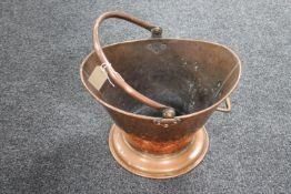 An antique hammered copper coal bucket