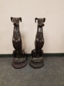 A pair of patinated figures of whippets on plinths,