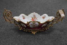 A decorative continental brass and china twin handled serving dish