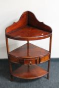 An eastern mahogany three tier corner washstand fitted a drawer