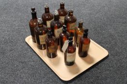 Eleven early 20th century brown glass chemist's bottles with stoppers bearing labels