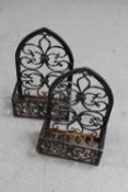 A pair of cast iron wall mounted flower baskets
