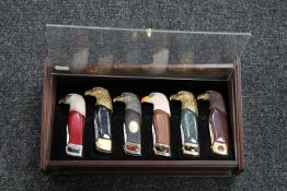 A counter top display case containing six eagle head handled lock knives