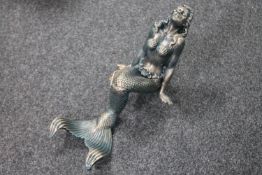 A cast iron figure of a seated mermaid