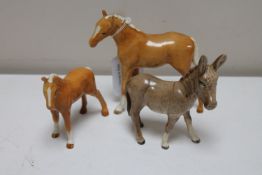 Two Beswick palomino ponies in gloss finish together with a Beswick donkey