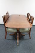 An inlaid mahogany Regency style twin pedestal dining table with leaf together with a set of four