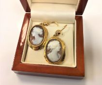 A pair of yellow metal mounted cameo drop earrings