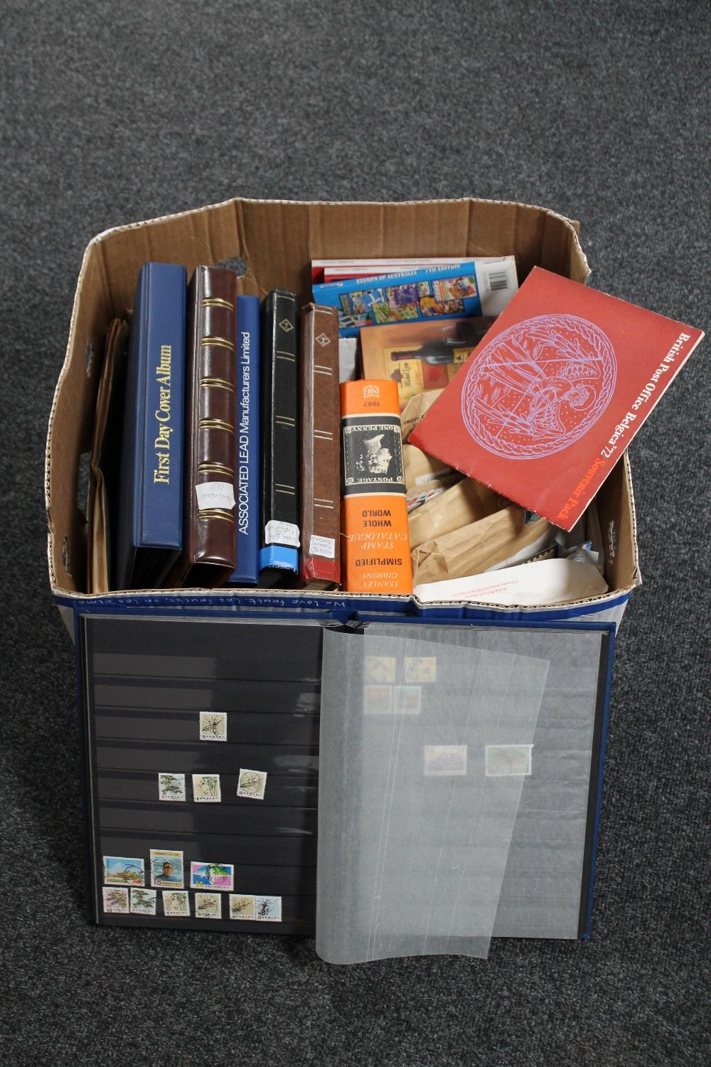 A box of six files and an album of first day covers and stamps, stamp collecting books,
