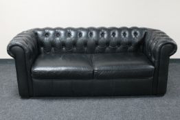 A black leather Chesterfield two seater settee