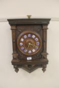 A continental carved wall clock with enamelled numbers