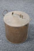An antique copper lidded twin handled pot