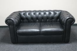 A black leather Chesterfield two seater settee