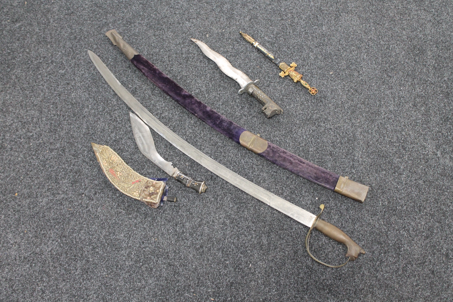 An Indian sword with scabbard and three other Eastern knives