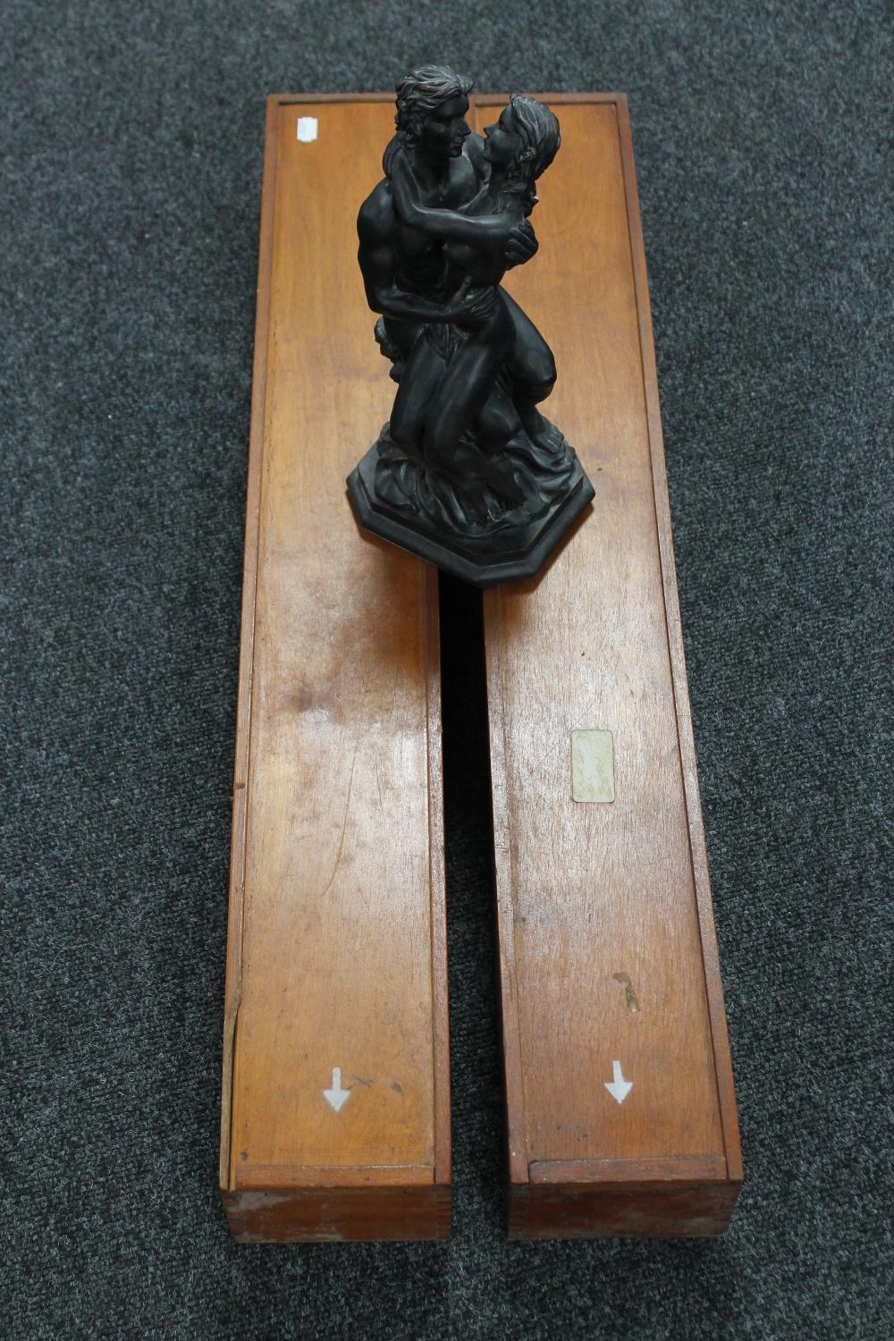 A resin figure of lovers and two wooden boxes with sliding lids