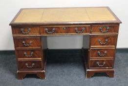 A Georgian style pedestal desk with tooled leather top