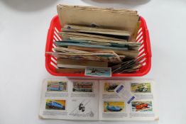 A basket of cigarette and tea card albums and loose tea cards