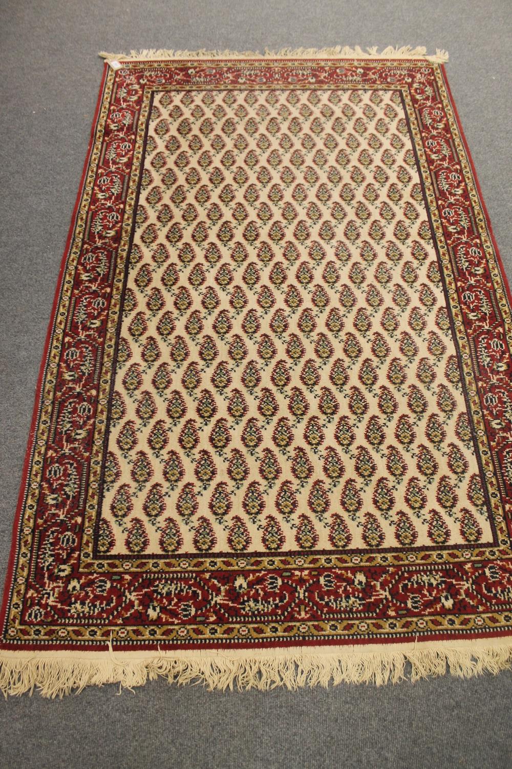 A fringed Eastern rug on cream ground