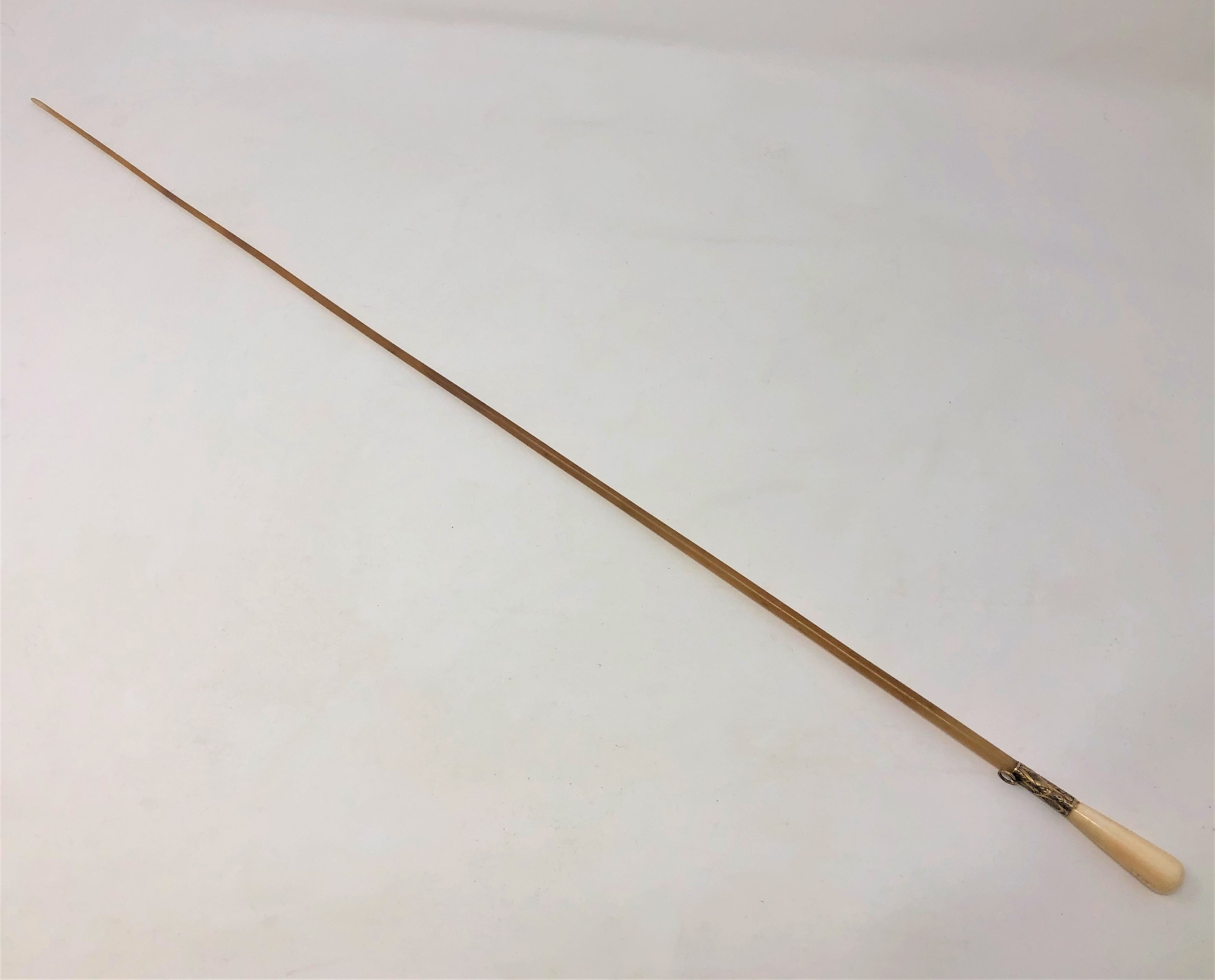 A late Victorian ivory and rhinoceros horn conductor's baton, with yellow metal ferrule,