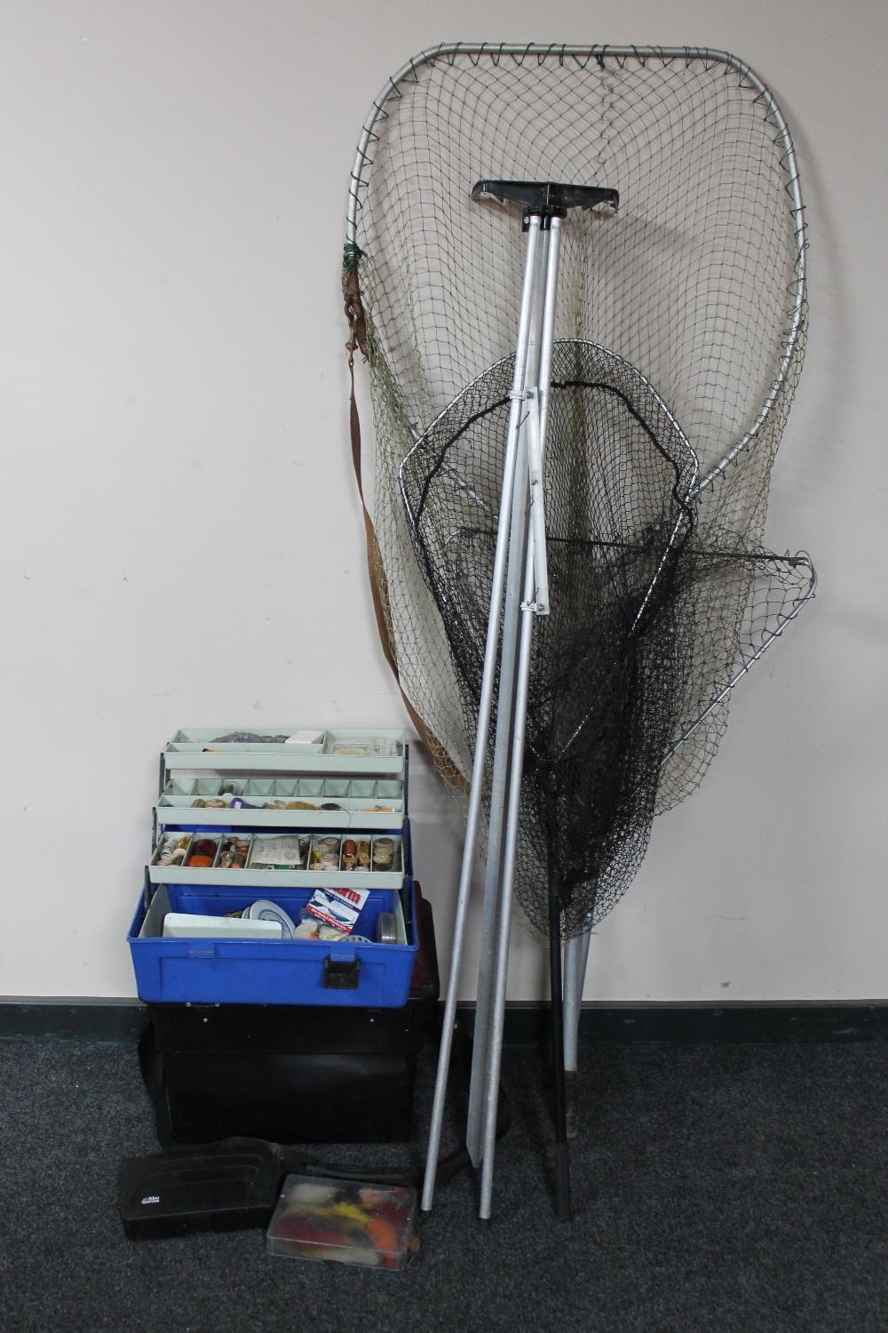 A quantity of fishing items to include nets, blue bait box with lures,