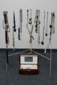 A folding clothes airer with a quantity of costume necklaces and a jewellery box of costume