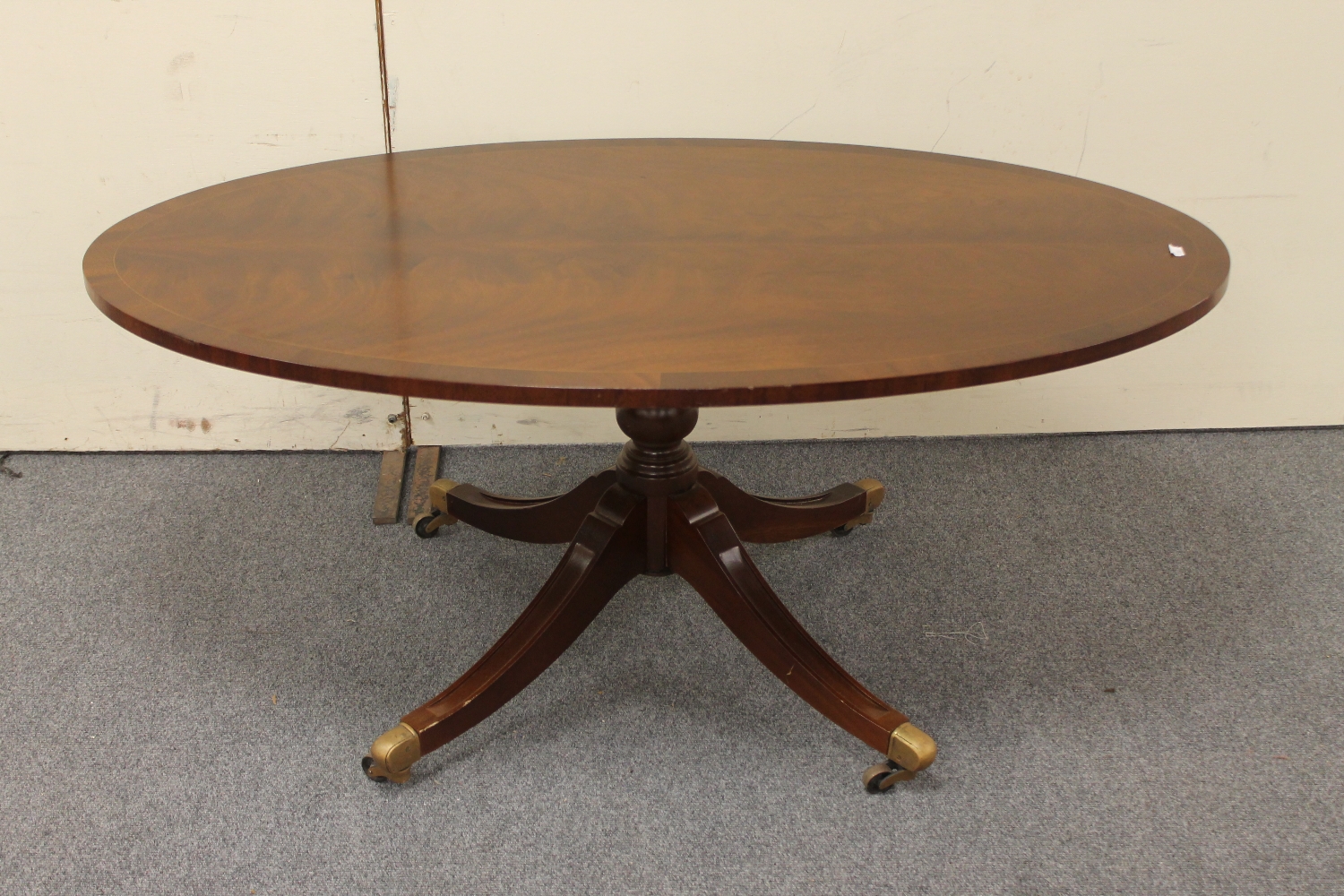 A reproduction oval pedestal coffee table
