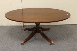 A reproduction oval pedestal coffee table