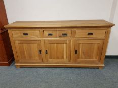 A contemporary oak sideboard fitted cupboards and drawers,
