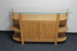 A contemporary oak side cabinet with glass top