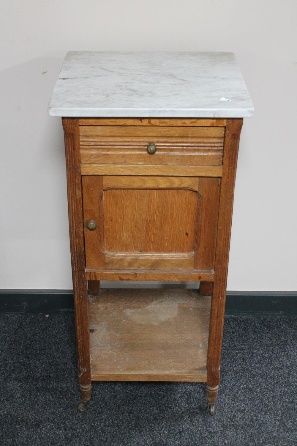 An Edwardian oak marble topped pot cupboard