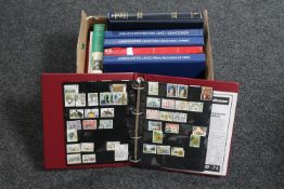 A box of seven files and an album of first day covers, two Stanley Gibbons stamp collecting books,