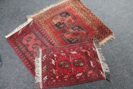 A fringed Persian rug and two fringed Persian hearth rugs